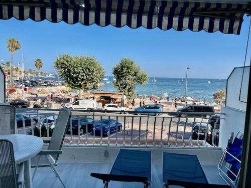 einen Balkon mit Blick auf den Strand und das Meer in der Unterkunft Très bel appartement sur la plage avec grande terrace face à la mer! La Goelette in Vallauris