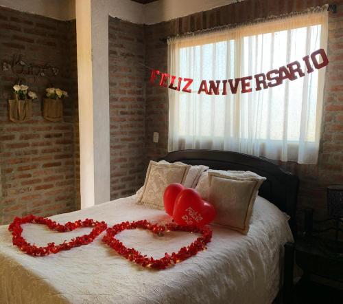 a bedroom with two hearts on a bed at Cabañas La Carolina - Mesa de Los Santos in Los Santos