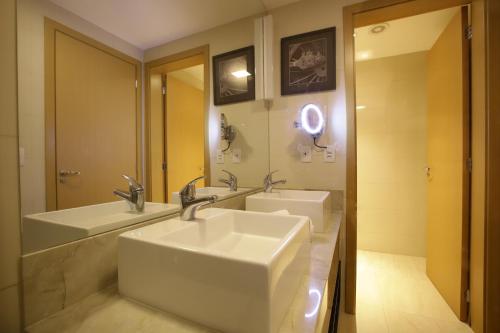 uma casa de banho com 2 lavatórios e um espelho em QS Marista 1202 CamasCasal em Goiânia