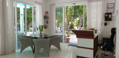 a dining room with a glass table and chairs at TME Retreats Dhigurah in Dhigurah