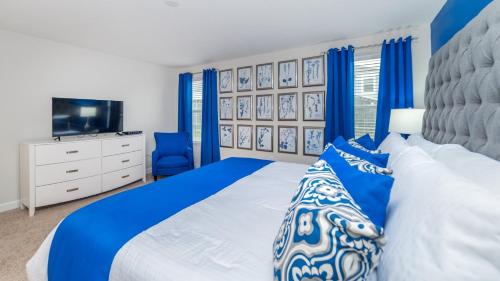 - une chambre bleue et blanche avec un lit et une télévision dans l'établissement Luxury 6 Bedroom Vacation Home, à Davenport