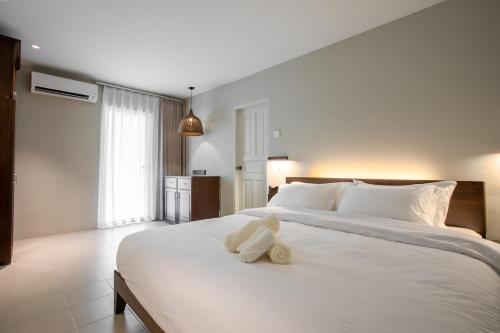 a white stuffed animal sitting on top of a bed at Kontor Mansion - 3 mins to Teluk Chempedak Beach & Private Pool in Kuantan