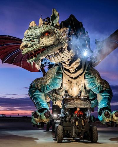 a person riding a quad bike in front of a dragon statue at L’Eden d’Opale in Coquelles