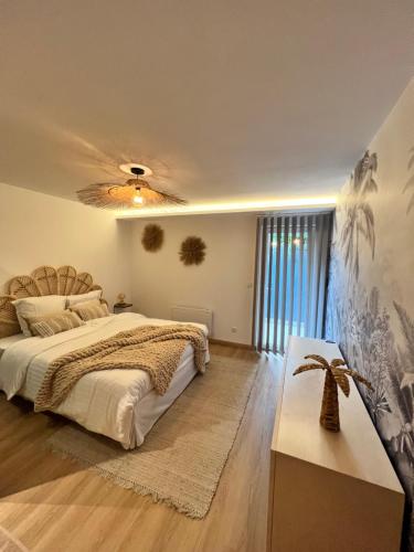 - une chambre avec un grand lit et un ventilateur de plafond dans l'établissement L’Eden d’Opale, à Coquelles