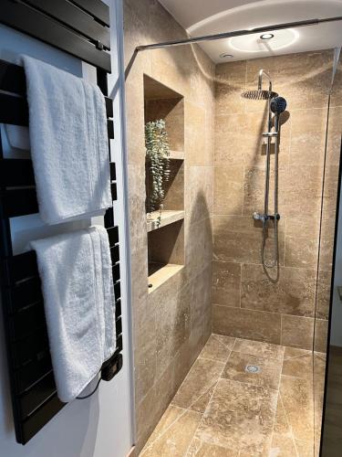 La salle de bains est pourvue d'une douche avec une porte en verre. dans l'établissement L’Eden d’Opale, à Coquelles