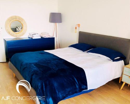 a bedroom with a large bed with a blue blanket at Appart'hotel grande terrasse vue mer in Ajaccio