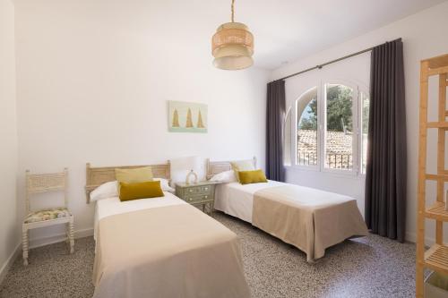 2 Betten in einem weißen Zimmer mit Fenster in der Unterkunft Torre Chiguita in Tarazona