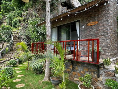 ein Haus mit einer roten Terrasse im Garten in der Unterkunft Gobies Garden in Mộc Châu