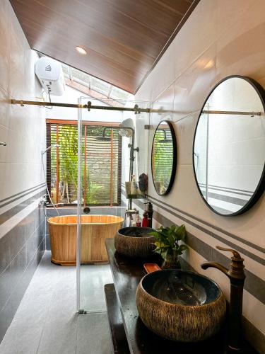 une salle de bain avec deux lavabos et un grand miroir dans l'établissement Gobies Garden, à Mộc Châu
