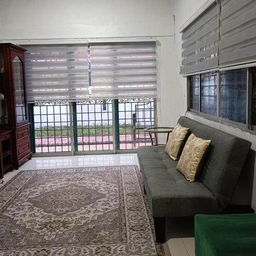 kak yatt homestay serendah في سيرينداه: غرفة معيشة مع أريكة ونافذة كبيرة