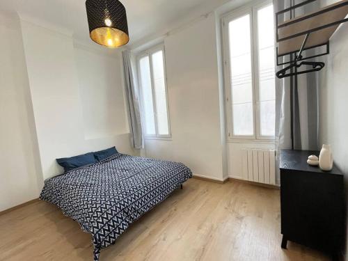 a bedroom with a black and white bed and two windows at Pleasant 3-bedroom flat in the center of Marseille in Marseille