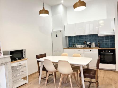 - une cuisine avec une table et des chaises blanches dans l'établissement Pleasant 3-bedroom flat in the center of Marseille, à Marseille