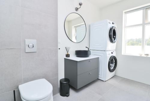 a white bathroom with a washing machine in it at G7 Akureyri Central Apartments in Akureyri