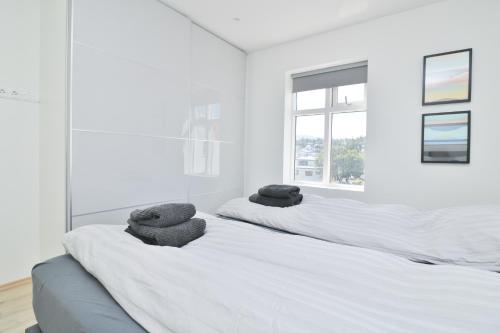 a white bedroom with two beds with towels on them at G7 Akureyri Central Apartments in Akureyri