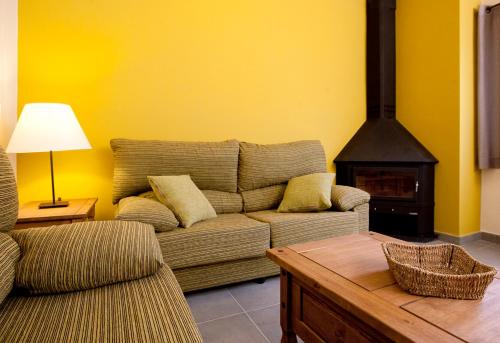 a living room with a couch and a fireplace at Apartaments Rural Montseny in gualba de Dalt