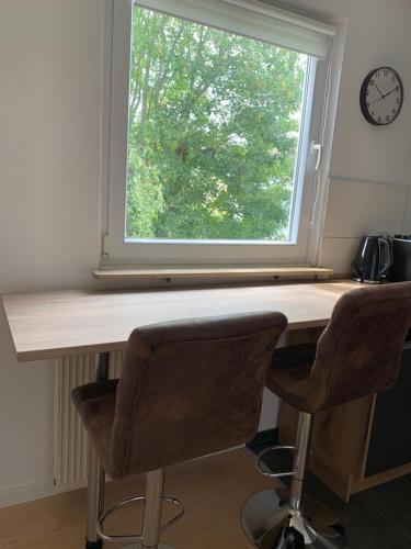 a desk with two chairs in front of a window at Ferienwohnung Herborn in Herborn