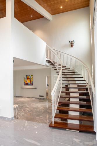 a staircase in a house with a white stair case at Kontor Mansion - 3 mins to Teluk Chempedak Beach & Private Pool in Kuantan