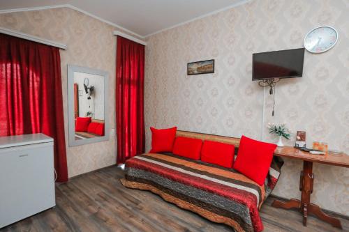 1 dormitorio con 1 cama con almohadas rojas en Boutique Old City Hotel, en Tiflis