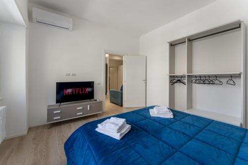 Schlafzimmer mit einem blauen Bett und einem TV in der Unterkunft Piazza Pio Suite Home in Rom