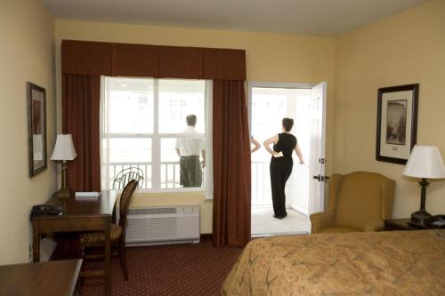 a woman looking out the window of a hotel room at Wine Country Inn in Palisade