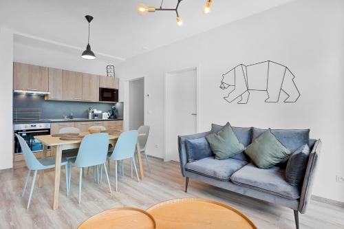 a living room with a couch and a table with chairs at Mirabel Apartments Klinovec in Loučná pod Klínovcem