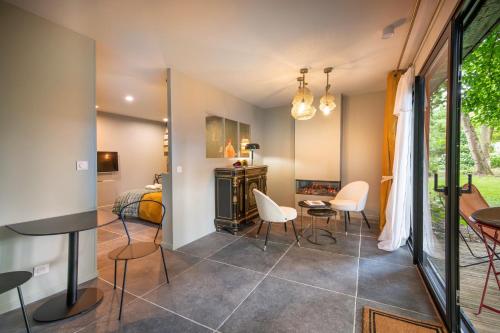 a room with a bed and a table and chairs at les Myrrhophores et Spa, Chambres d'Hôtes et Gîtes de charme in Abbeville