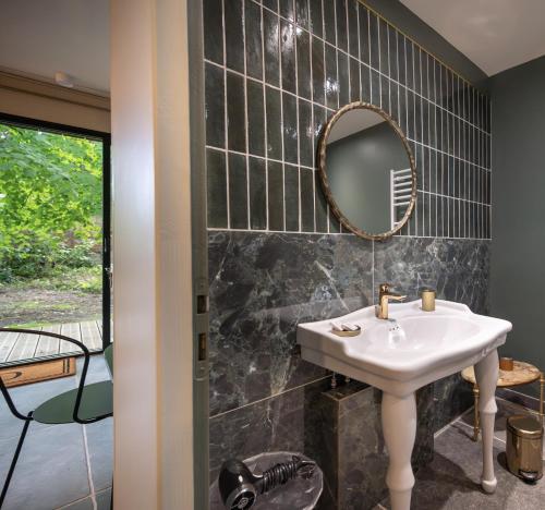 a bathroom with a sink and a mirror at les Myrrhophores et Spa, Chambres d'Hôtes et Gîtes de charme in Abbeville