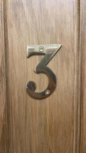 a metal door number on a wooden door at The White Horse Inn, Clun in Clun