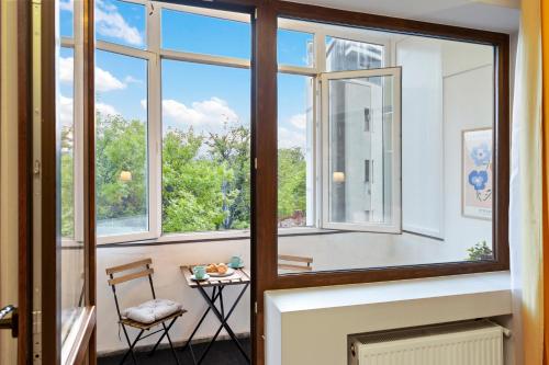 a room with windows and a table and a chair at City Heart Retreat Elegant Apartment in Bucharest