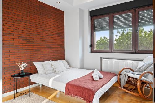a bedroom with a bed and a brick wall at City Heart Retreat Elegant Apartment in Bucharest