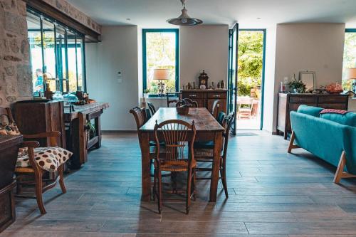 une salle à manger avec une table et des chaises dans l'établissement Les jardins de Nanine, à Lapleau