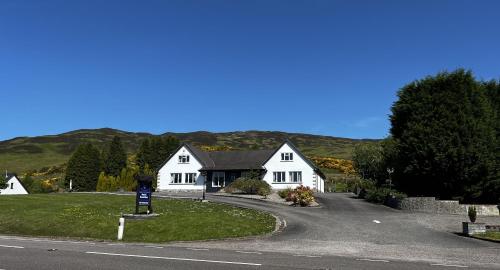 a white house on the side of a road at Springburn Farmhouse in Spean Bridge