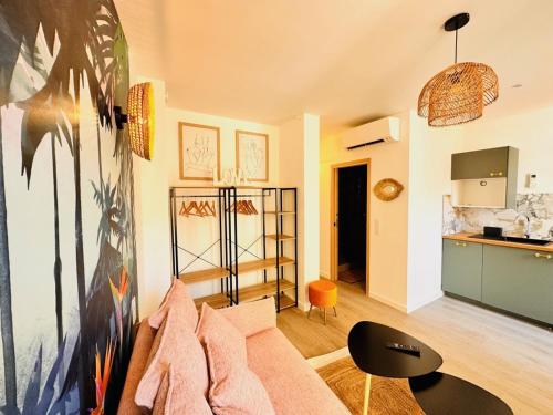 un salon avec un canapé et une cuisine dans l'établissement Les Appartements de Nana 8 - Studio hypercentre, Rue Meynadier, Palais & Plage, clim, wifi, à Cannes