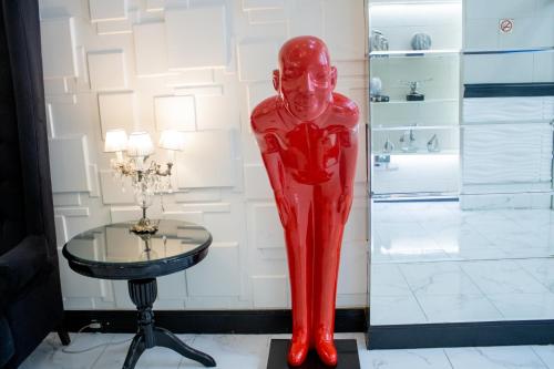 a red statue of a woman next to a table at Ker Recoleta Hotel in Buenos Aires