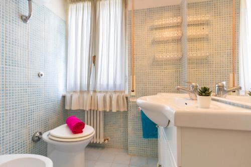 ein Bad mit einem WC und einem rosa Handtuch darauf in der Unterkunft Appartamento Clarice - MyHo Casa in Martinsicuro