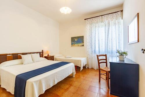 ein Schlafzimmer mit einem Bett, einem Stuhl und einem Fenster in der Unterkunft Appartamento Clarice - MyHo Casa in Martinsicuro