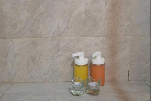 two bottles of honey and glasses on a counter at Très bel appartement en face du parc, près du Novotel in Mohammedia