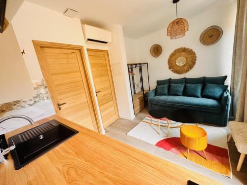 un salon avec un canapé vert et une table dans l'établissement Les Appartements de Nana 6 - Studio hypercentre, Rue Meynadier, Palais & Plage, clim, wifi, à Cannes