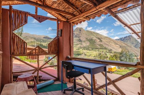 Cette chambre dispose d'une table et offre une vue sur les montagnes. dans l'établissement Wallpari Sonqo Hospedaje Medicina temazcal, à Pisac