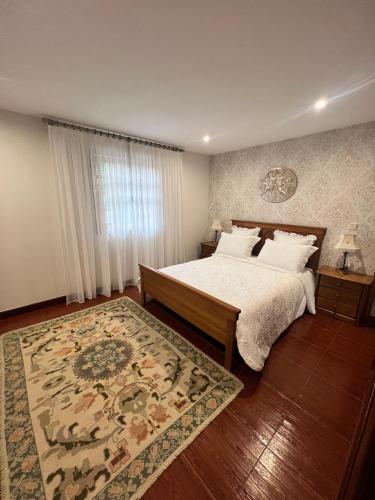 a bedroom with a large bed and a rug at Bouça do Sossego in Ribeirão