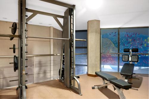 a gym with a bench and a chair in a room at Sesimbra Oceanfront Hotel - Preferred Hotels and Resorts in Sesimbra