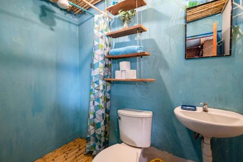 a blue bathroom with a toilet and a sink at Wallpari Sonqo Hospedaje Medicina temazcal in Pisac