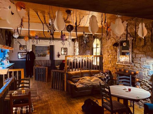 uma sala de estar com um sofá e uma parede de pedra em The Welshman’s Arms em Pembrokeshire