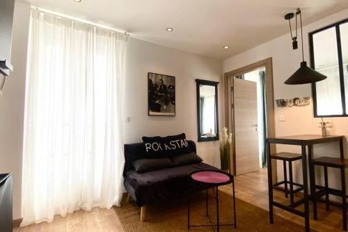 a living room with a couch and a table at appartement avec vue jardin proche de Paris in Saint-Maurice
