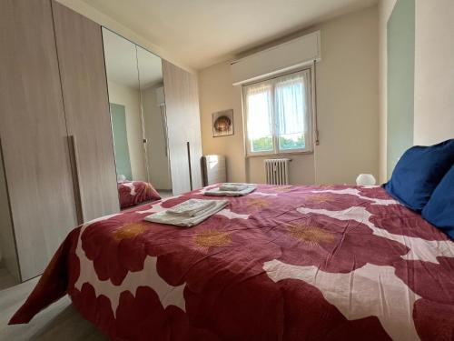 a bedroom with a bed with a red and white blanket at Stazione a 400 metriTeds Home in Melegnano