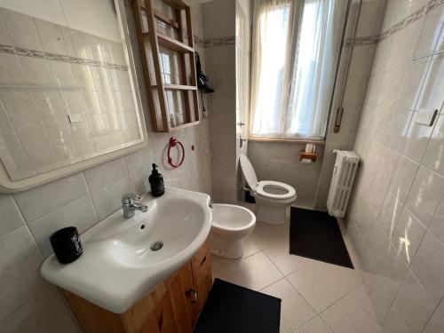 a white bathroom with a sink and a toilet at Stazione a 400 metriTeds Home in Melegnano