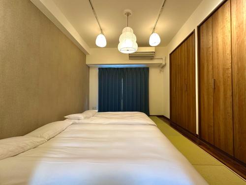 a row of beds in a room with lights at 浅草寺3分 浅草駅6分 寝室+リビング2-4人 スカイツリービュー 駅近 成田空港&羽田空港直通 in Tokyo