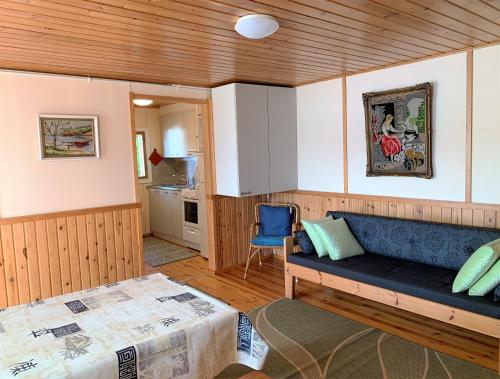 een woonkamer met een bank en een bed bij Lappalaisen lomamökit Suviranta in Puumala