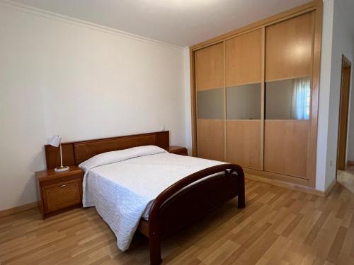 1 dormitorio con 1 cama y armario grande en Alojamento dos Redondos, en Fernao Ferro