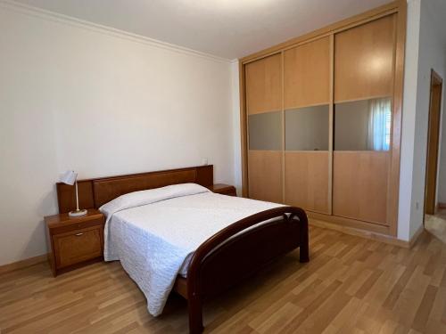 a bedroom with a bed and a large closet at Alojamento dos Redondos in Fernao Ferro